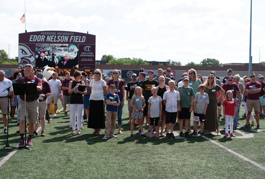 Friends and Family of pastor Dave Wold gather on the Augsburg field to see the unveiling of the Press Box